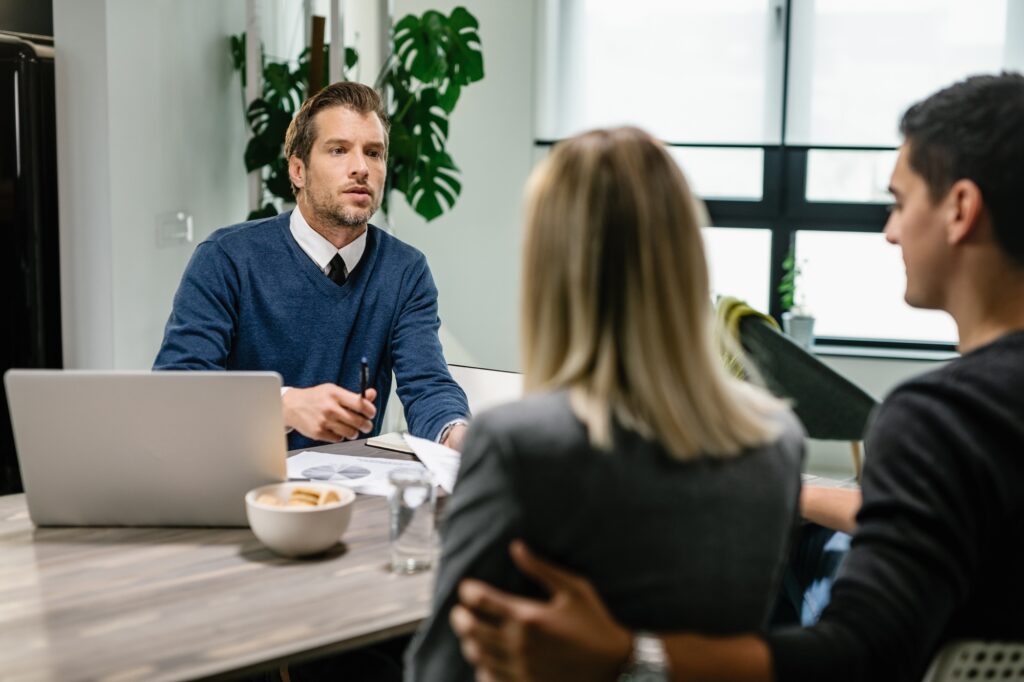 Insurance agent having a meeting with a couple at their home.